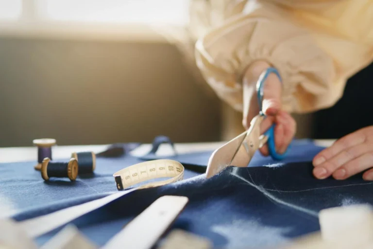 athletic shorts manufacturer fabric cutting with scissors and measuring tools